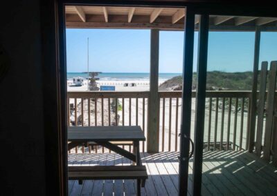 View of beach from sliding glass door to balcony