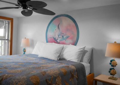 Room 4 - ing bed with mural of a dolphin painted on wall