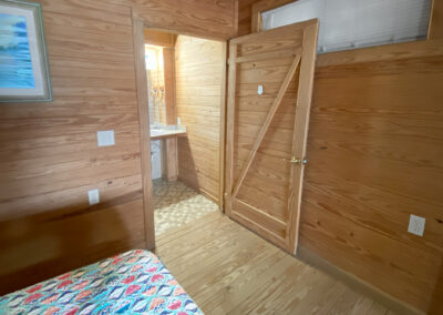 Room 7 - bed with wooden paneled door to bathroom