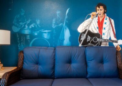 Elvis Presley mural on wall behind sofa