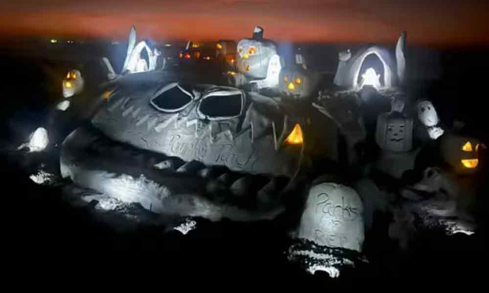 Sand pumpkins lit at night.