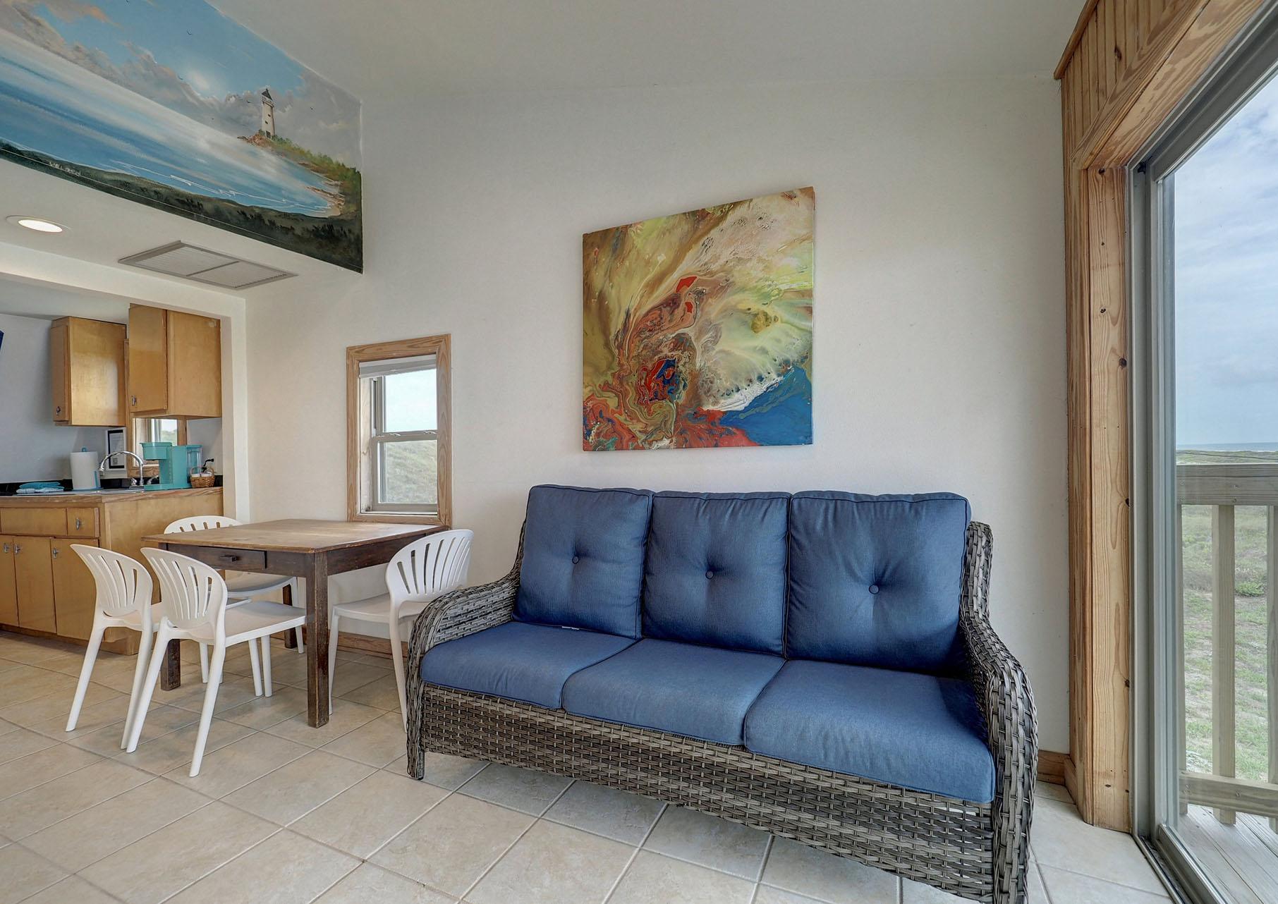 Table and chairs and blue rattan sofa